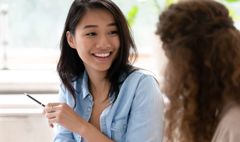 Two women sit close together and chat