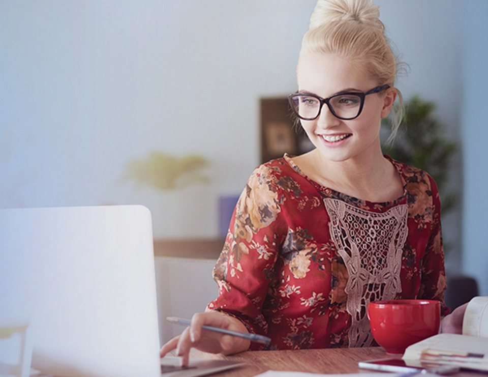 A woman sits at a computer and works